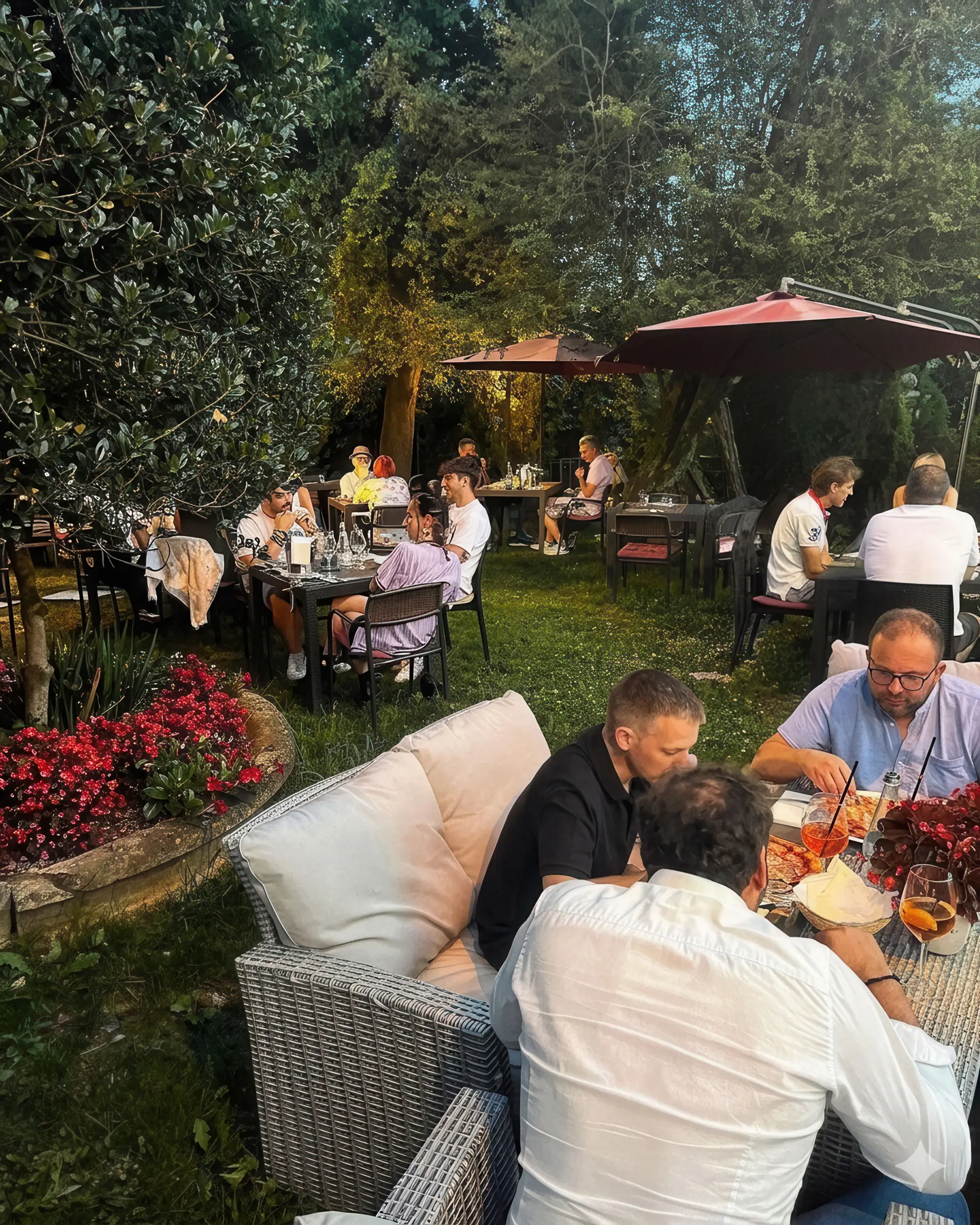 Ospiti cenano ai tavoli esterni del Boogie Bistrot illuminati da luci soffuse a Colle Brianza