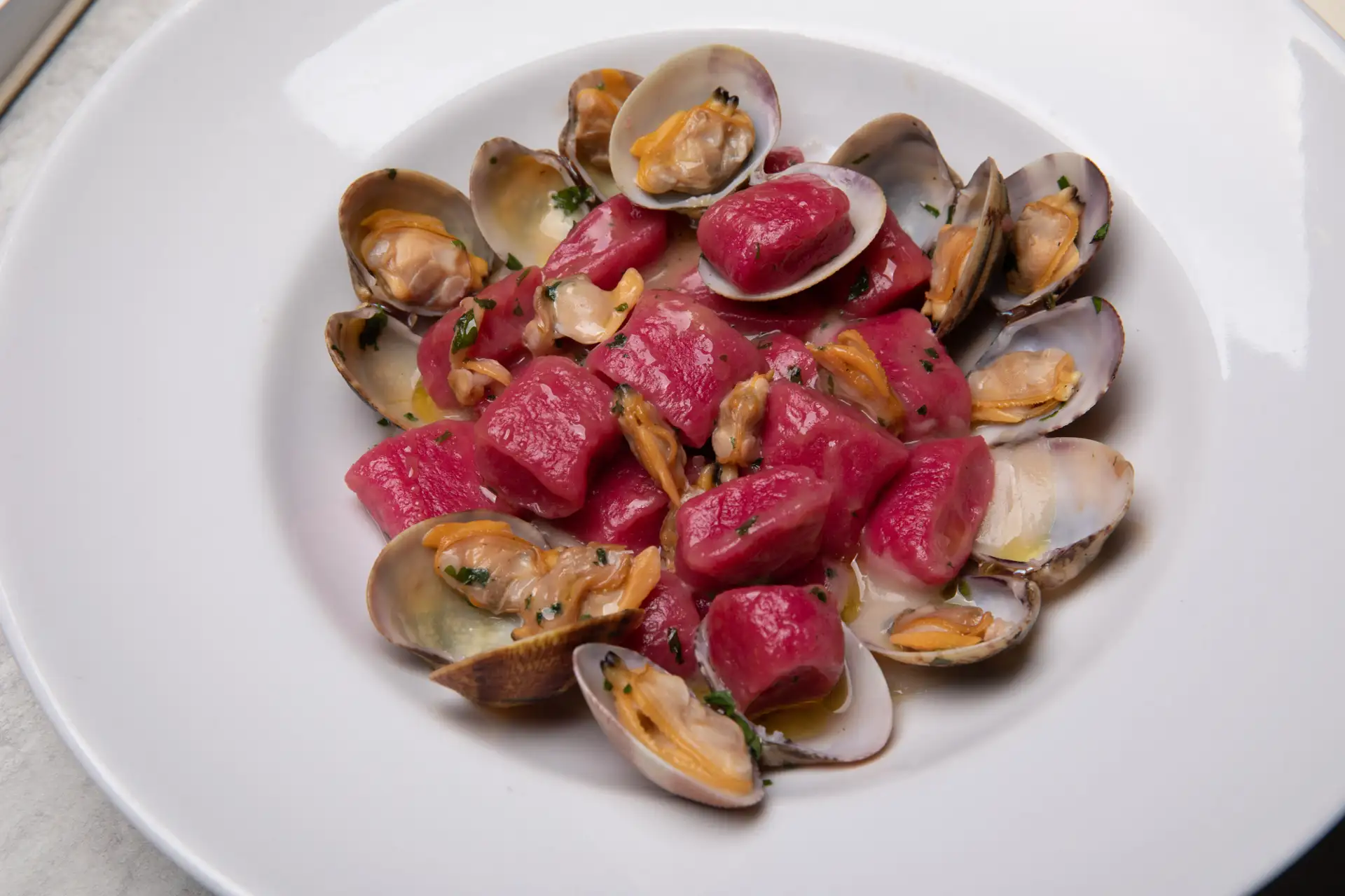 Gnocchetti di barbabietola con vongole veraci su crema di cannellini