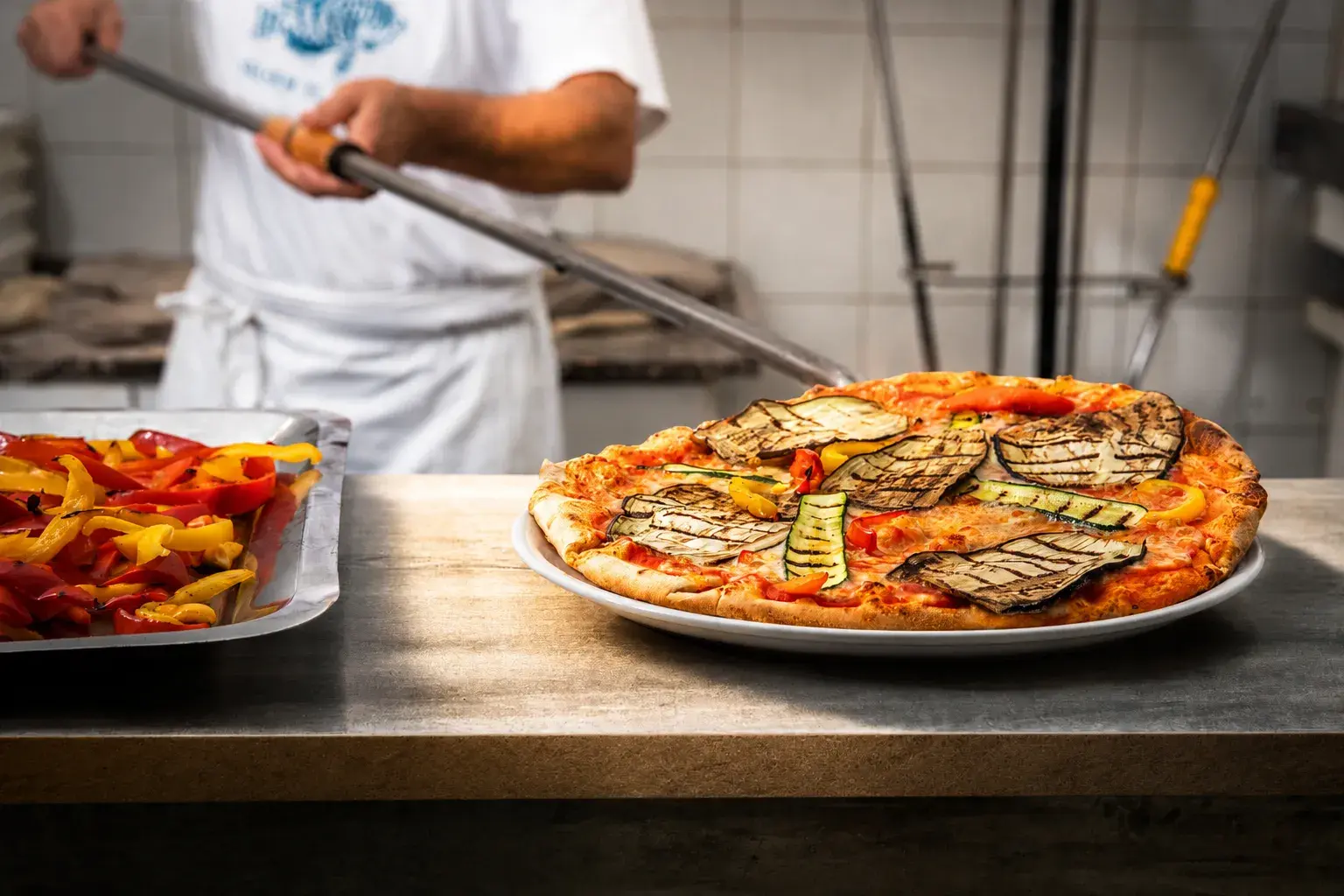 Pizzaiolo del Boogie Bistrot prepara pizza appena sfornata a Colle Brianza