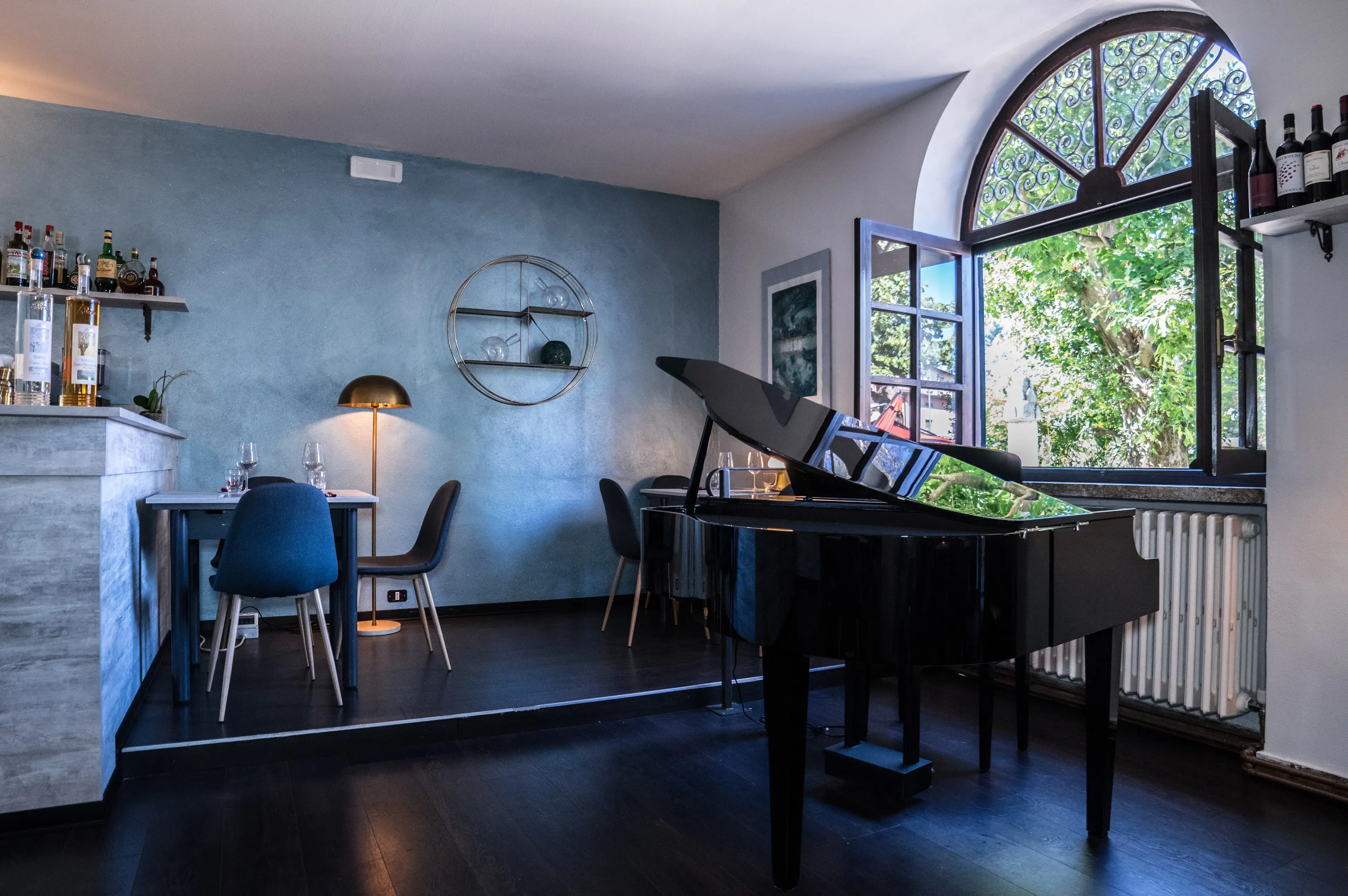 Interno del Boogie Bistrot: pianoforte a coda nero tra arredo moderno in location storica