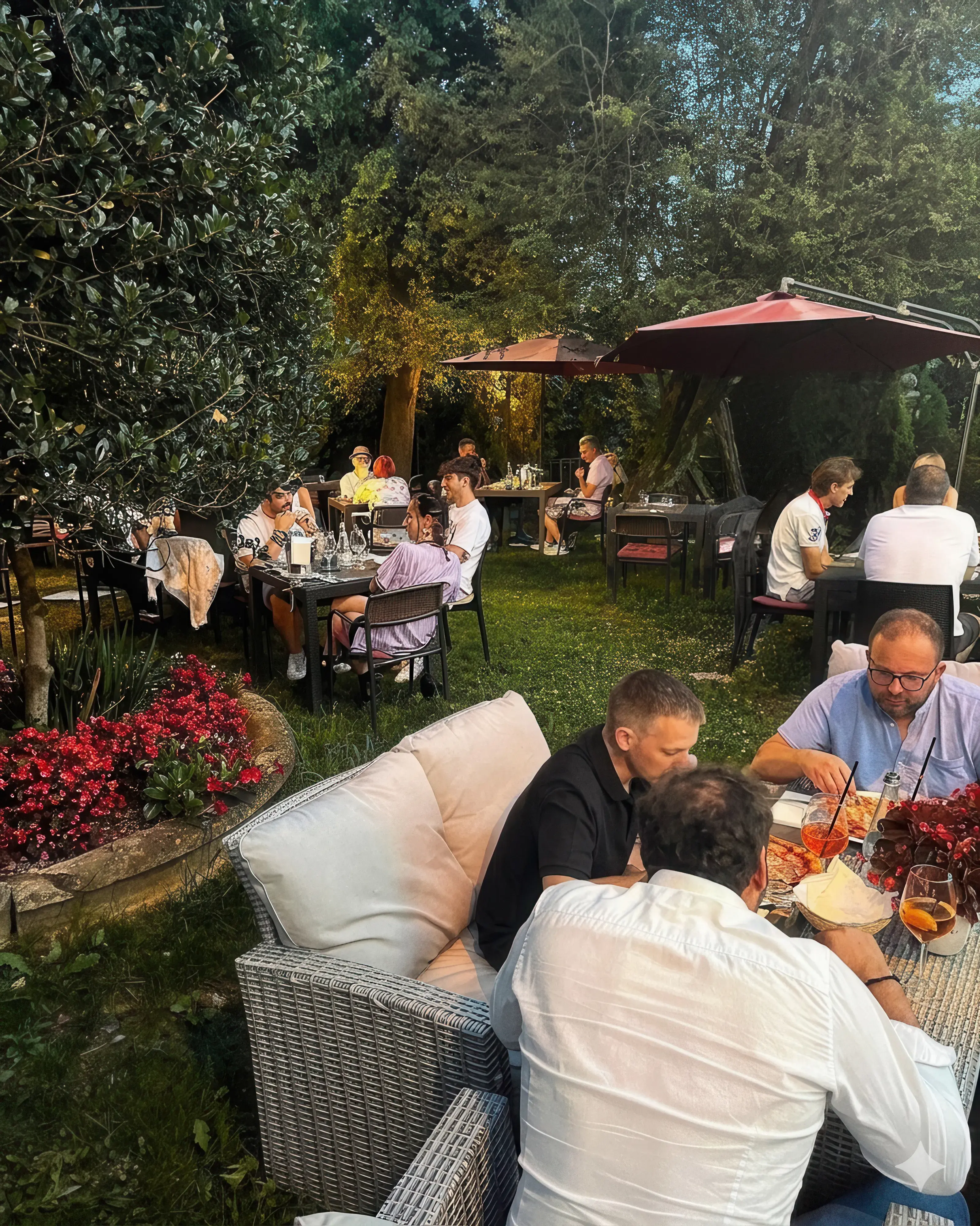 Ospiti cenano ai tavoli esterni del Boogie Bistrot illuminati da luci soffuse a Colle Brianza